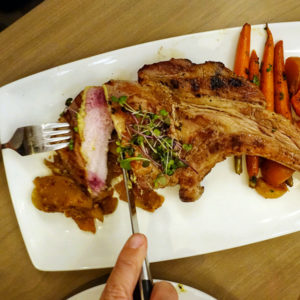 Calgary Bearspaw restaurant Flores & Pine pork tomahawk carrots eating